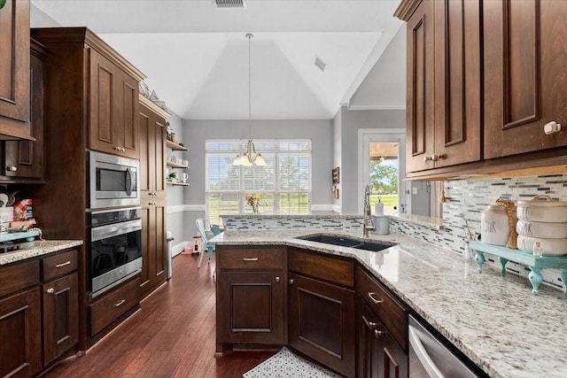 231 N Waterstone Dr, Montgomery, TX 77356 - kitchen featuring appliances with stainless steel finishes, a sink, vaulted ceiling, a peninsula, and decorative backsplash