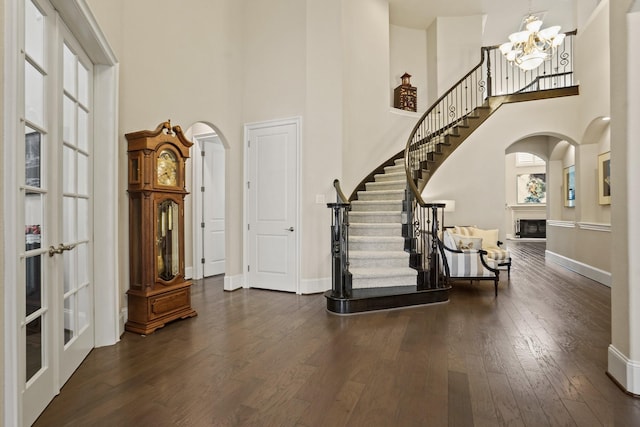9810 Mount Whitney, Missouri City, TX 77459 - entrance foyer featuring a high ceiling, a fireplace, arched walkways, hardwood / wood-style floors, and a chandelier