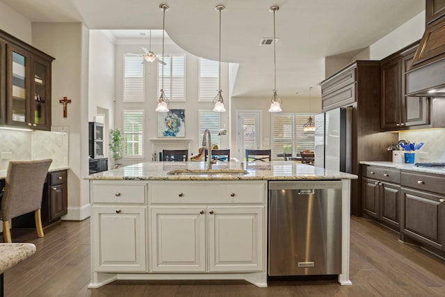 9810 Mount Whitney, Missouri City, TX 77459 - kitchen with stainless steel dishwasher, a sink, dark brown cabinetry, an island with sink, and hanging light fixtures