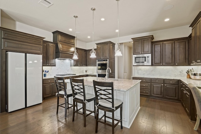 9810 Mount Whitney, Missouri City, TX 77459 - kitchen featuring appliances with stainless steel finishes, a kitchen island with sink, dark brown cabinetry, a sink, and recessed lighting