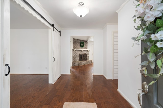 215 Whispering Oaks Dr, Taylor Lake Village, TX 77586 - corridor featuring a barn door, wood finished floors, baseboards, and ornamental molding