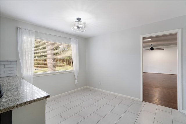 215 Whispering Oaks Dr, Taylor Lake Village, TX 77586 - unfurnished dining area with ceiling fan, light tile patterned flooring, a chandelier, and baseboards