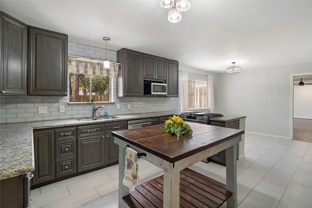 215 Whispering Oaks Dr, Taylor Lake Village, TX 77586 - kitchen with a sink, backsplash, light tile patterned floors, decorative light fixtures, and stainless steel appliances