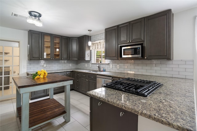 215 Whispering Oaks Dr, Taylor Lake Village, TX 77586 - kitchen with stainless steel appliances, a sink, decorative backsplash, and dark stone counters