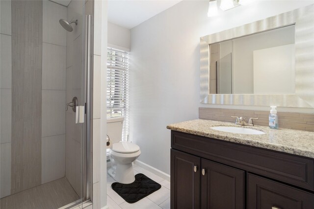 215 Whispering Oaks Dr, Taylor Lake Village, TX 77586 - full bathroom with a shower stall, vanity, toilet, tasteful backsplash, and tile patterned flooring