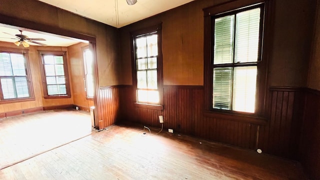 614 18th St, Galveston, TX 77550 - spare room featuring ceiling fan, a wainscoted wall, wood finished floors, and wood walls