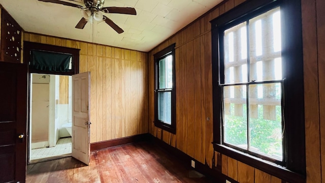 614 18th St, Galveston, TX 77550 - spare room with wood finished floors, wooden walls, ceiling fan, and baseboards