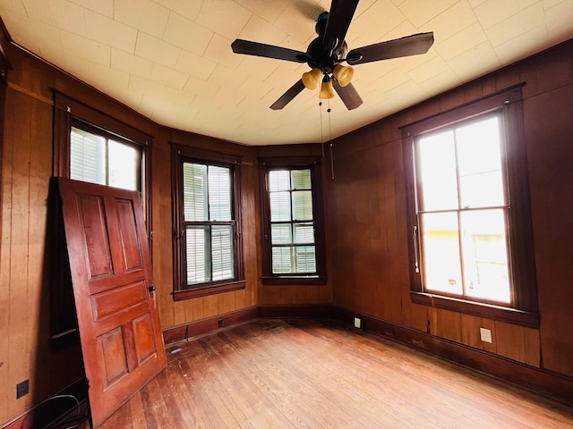 614 18th St, Galveston, TX 77550 - spare room featuring wood finished floors, wood walls, ceiling fan, and baseboards