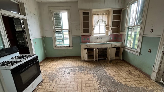 614 18th St, Galveston, TX 77550 - kitchen featuring gas range, light flooring, a sink, light countertops, and baseboards