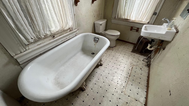 614 18th St, Galveston, TX 77550 - full bathroom featuring a soaking tub, toilet, tile patterned floors, and a sink