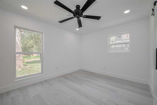 15622 Corsair Rd, Houston, TX 77053 - empty room featuring plenty of natural light, recessed lighting, light wood-style floors, ceiling fan, and a barn door