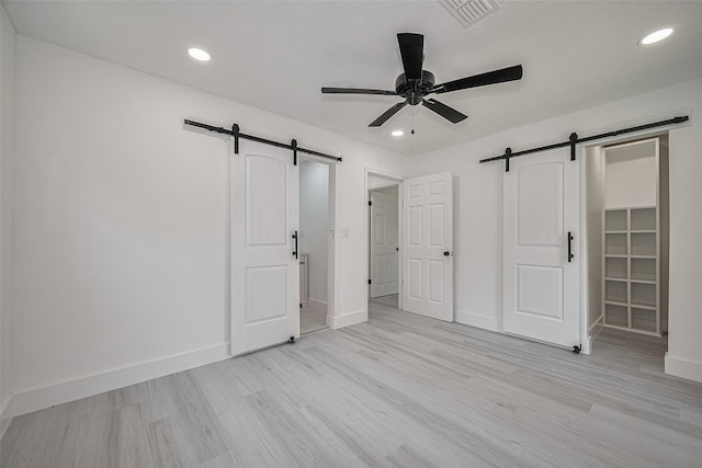 15622 Corsair Rd, Houston, TX 77053 - unfurnished bedroom featuring a barn door, light wood-style flooring, baseboards, and recessed lighting