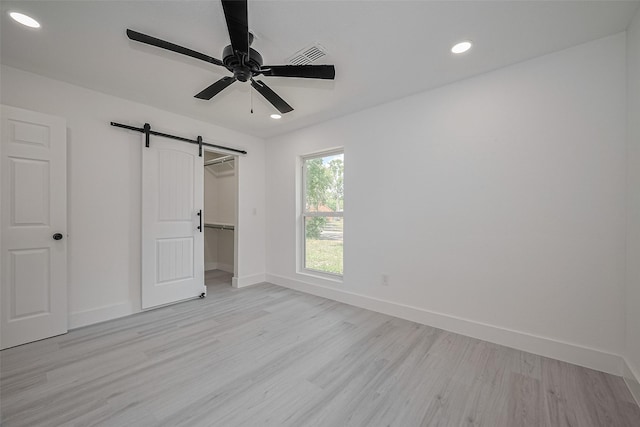 15622 Corsair Rd, Houston, TX 77053 - unfurnished bedroom featuring a barn door, light wood-type flooring, baseboards, recessed lighting, and ceiling fan