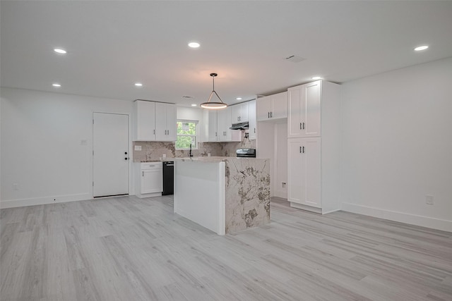 15622 Corsair Rd, Houston, TX 77053 - kitchen with black dishwasher, light wood finished floors, under cabinet range hood, white cabinets, and tasteful backsplash