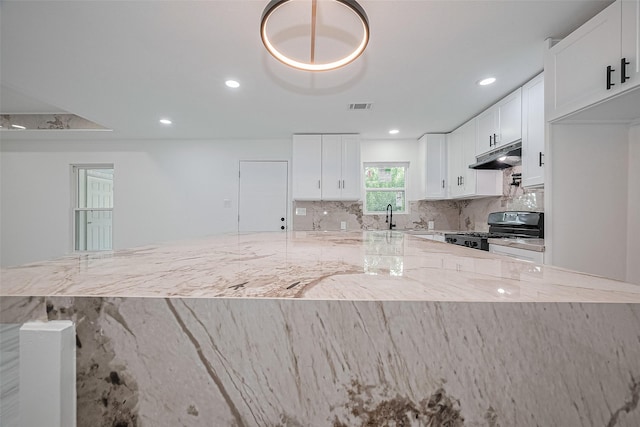 15622 Corsair Rd, Houston, TX 77053 - kitchen with range with gas stovetop, under cabinet range hood, light stone counters, white cabinetry, and recessed lighting