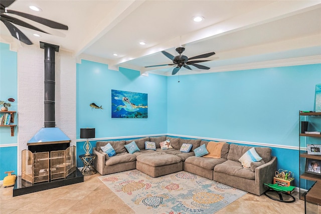 3415 80th St, Galveston, TX 77551 - living room with ceiling fan, a wood stove, beam ceiling, tile patterned flooring, and ornamental molding