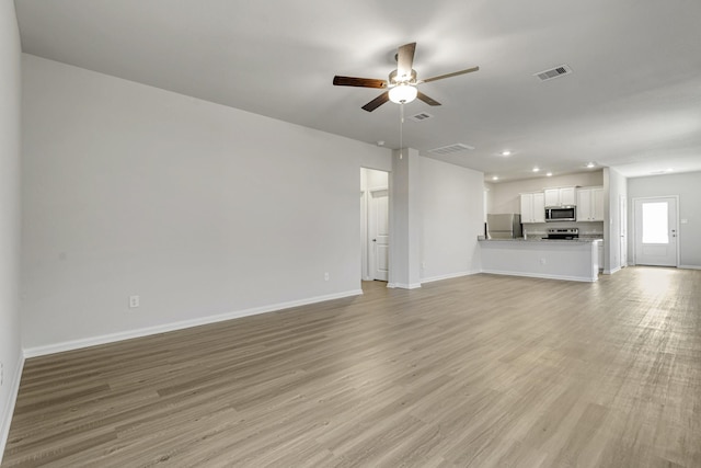 6426 Summer Pass Dr, Houston, TX 77048 - unfurnished living room with a ceiling fan, baseboards, light wood-type flooring, and recessed lighting