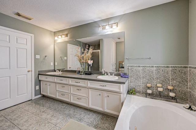 236 Mcfarland Rd, Houston, TX 77060 - full bath with double vanity, a whirlpool tub, tile patterned flooring, a textured ceiling, and a stall shower