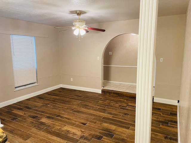 7635 Nordling Rd, Houston, TX 77037 - spare room featuring ceiling fan, arched walkways, dark wood finished floors, and baseboards