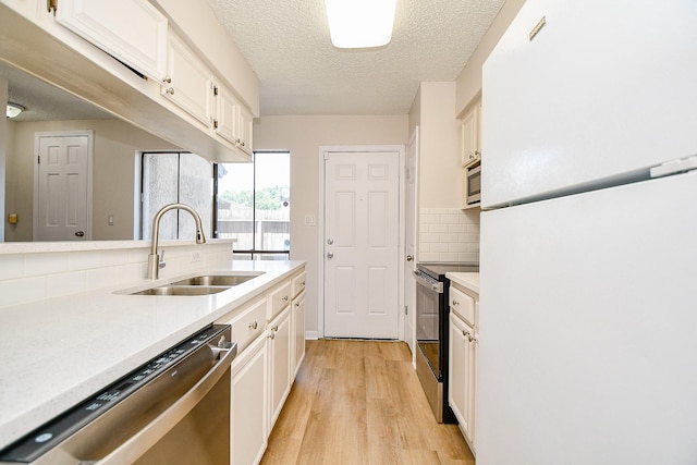 5001 Lamonte Ln Unit 14, Houston, TX 77092 - kitchen featuring appliances with stainless steel finishes, a sink, light countertops, tasteful backsplash, and light wood-style flooring