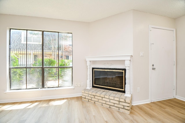 5001 Lamonte Ln Unit 14, Houston, TX 77092 - unfurnished living room featuring wood finished floors, a brick fireplace, and baseboards