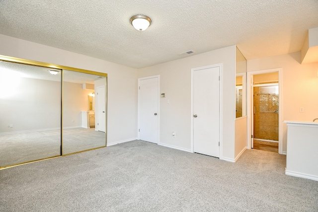 5001 Lamonte Ln Unit 14, Houston, TX 77092 - unfurnished bedroom featuring carpet floors, a closet, a textured ceiling, and baseboards