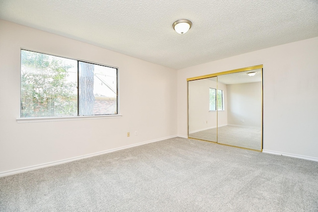 5001 Lamonte Ln Unit 14, Houston, TX 77092 - unfurnished bedroom featuring carpet floors, a closet, a textured ceiling, and baseboards