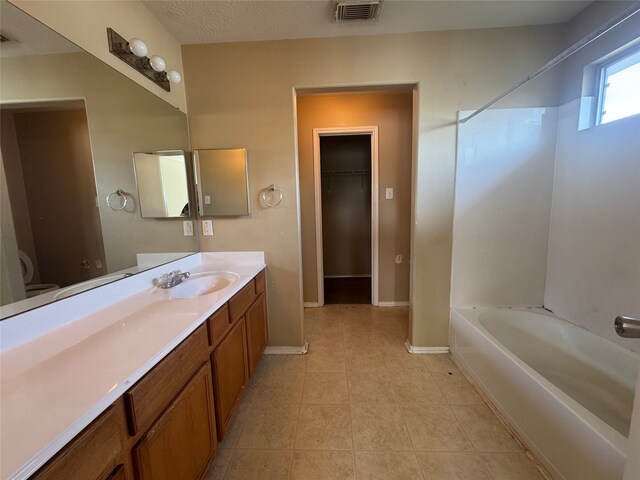3406 Chateaucrest Ct, Houston, TX 77047 - bathroom featuring vanity, shower / bathtub combination, tile patterned floors, baseboards, and a walk in closet