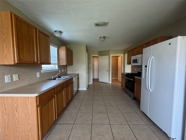 3406 Chateaucrest Ct, Houston, TX 77047 - kitchen featuring white appliances, a sink, light tile patterned floors, light countertops, and a textured ceiling