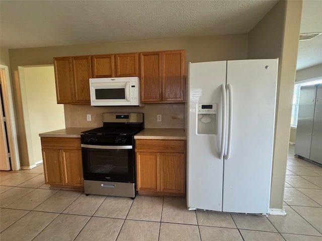3406 Chateaucrest Ct, Houston, TX 77047 - kitchen featuring white appliances, light tile patterned floors, light countertops, and brown cabinetry