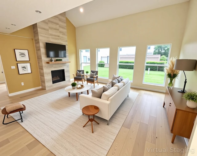 6658 Radley Dr, Spring, TX 77379 - living area featuring plenty of natural light, a high end fireplace, light wood-style flooring, baseboards, and high vaulted ceiling