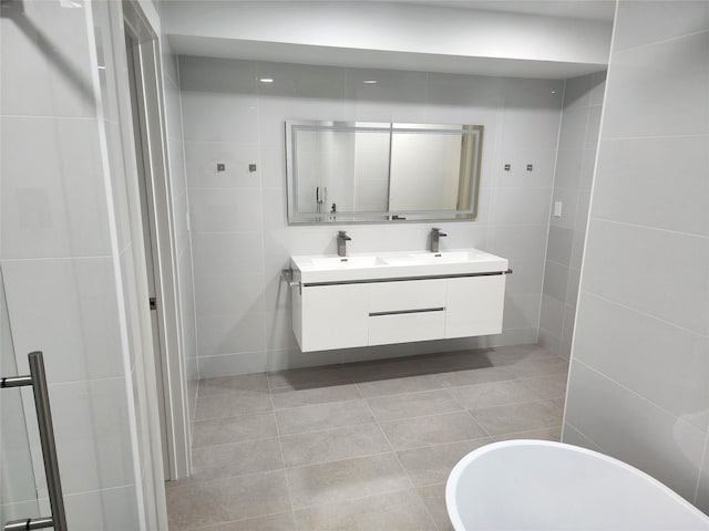 6658 Radley Dr, Spring, TX 77379 - full bathroom featuring tile walls, double vanity, and tile patterned flooring
