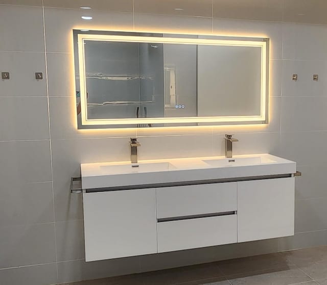 6658 Radley Dr, Spring, TX 77379 - bathroom featuring tile walls, double vanity, and tile patterned flooring