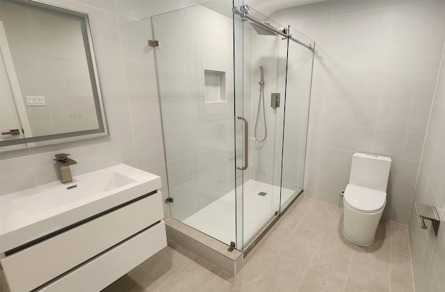 6658 Radley Dr, Spring, TX 77379 - bathroom featuring tile walls, vanity, a shower stall, toilet, and tile patterned flooring