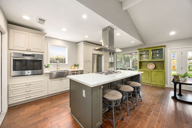 10718 Dunlap St, Houston, TX 77096 - kitchen featuring stainless steel appliances, a sink, island range hood, a kitchen breakfast bar, and light countertops