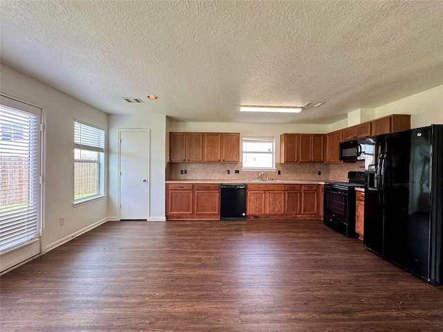 15507 Liberty Bluff Dr, Houston, TX 77049 - kitchen featuring black appliances, a sink, a textured ceiling, dark wood finished floors, and light countertops