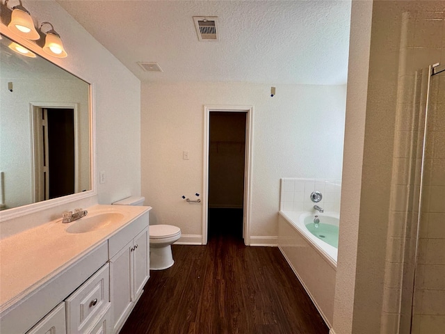 15507 Liberty Bluff Dr, Houston, TX 77049 - bathroom with toilet, wood finished floors, vanity, a bath, and baseboards