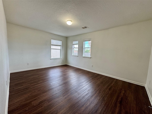 15507 Liberty Bluff Dr, Houston, TX 77049 - unfurnished room featuring dark wood-style floors, baseboards, and a textured ceiling