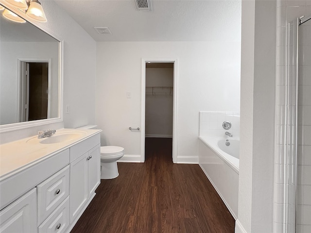 15507 Liberty Bluff Dr, Houston, TX 77049 - bathroom with wood finished floors, a bath, vanity, and a spacious closet