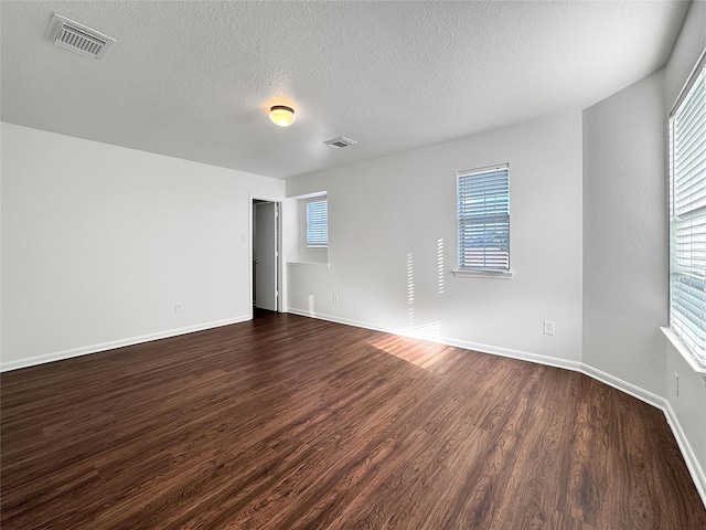 15507 Liberty Bluff Dr, Houston, TX 77049 - empty room with dark wood-type flooring, healthy amount of natural light, and a textured ceiling