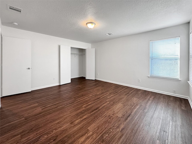 15507 Liberty Bluff Dr, Houston, TX 77049 - unfurnished bedroom with dark wood finished floors, a textured ceiling, and a closet