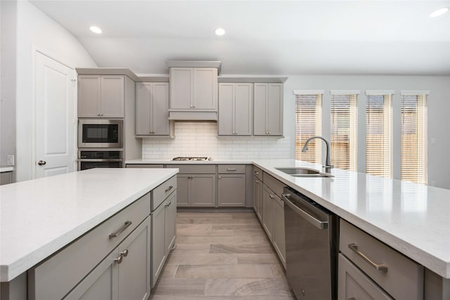 15711 Autumn Sun Ct, Conroe, TX 77302 - kitchen with gray cabinetry, appliances with stainless steel finishes, a sink, recessed lighting, and decorative backsplash