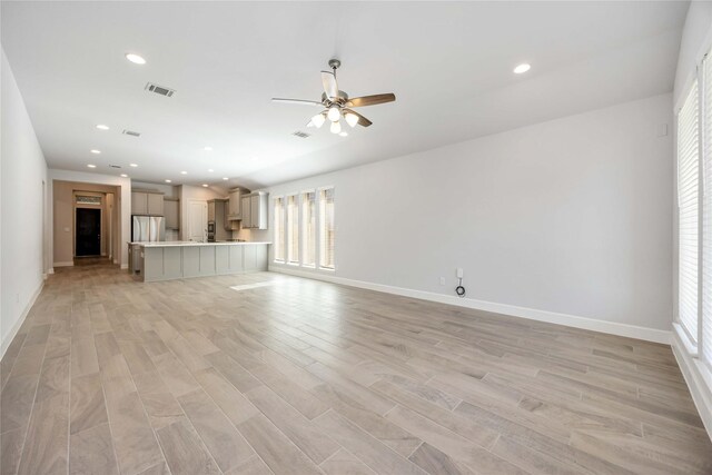 15711 Autumn Sun Ct, Conroe, TX 77302 - unfurnished living room featuring a ceiling fan, light wood-style flooring, baseboards, and recessed lighting