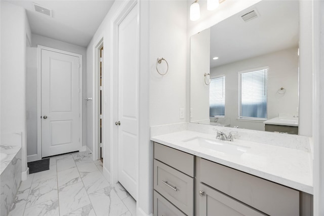 15711 Autumn Sun Ct, Conroe, TX 77302 - bathroom with marble look tiles, vanity, and a tub with marble appearance