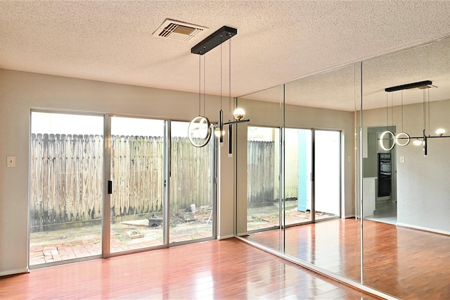 3114 Hollow Creek Ct, Houston, TX 77082 - unfurnished dining area featuring a chandelier, a textured ceiling, and wood finished floors