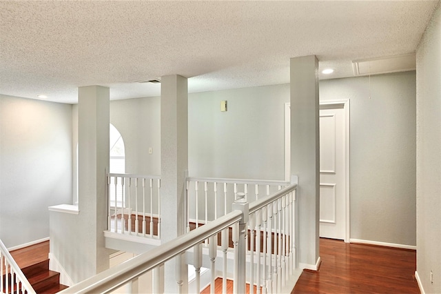 3114 Hollow Creek Ct, Houston, TX 77082 - corridor featuring attic access, an upstairs landing, wood finished floors, a textured ceiling, and baseboards