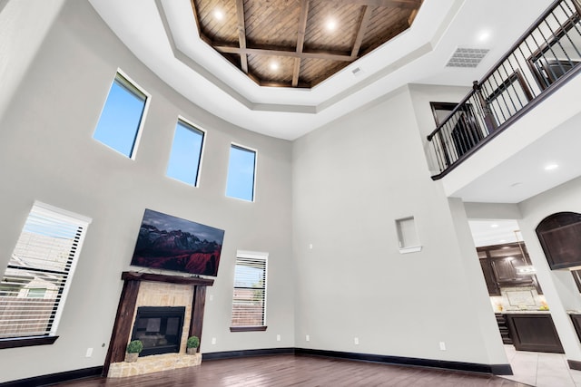 5912 T St, Katy, TX 77493 - unfurnished living room featuring a high ceiling, wood ceiling with exposed beams, a glass covered fireplace, recessed lighting, and coffered ceiling
