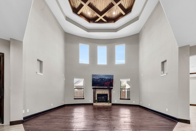 5912 T St, Katy, TX 77493 - unfurnished living room with a high ceiling, plenty of natural light, wood-type flooring, a glass covered fireplace, and coffered ceiling
