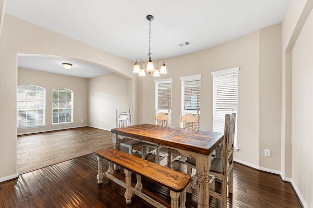 406 Oak Stream Dr, Conroe, TX 77304 - dining space with arched walkways, a chandelier, dark wood-style floors, and baseboards