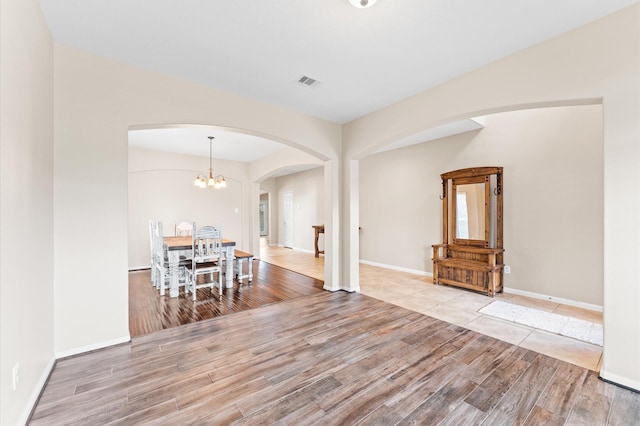 406 Oak Stream Dr, Conroe, TX 77304 - dining room featuring arched walkways, wood finished floors, a chandelier, and baseboards